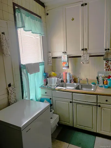 a room with kitchen island granite countertop wooden cabinets and white appliances