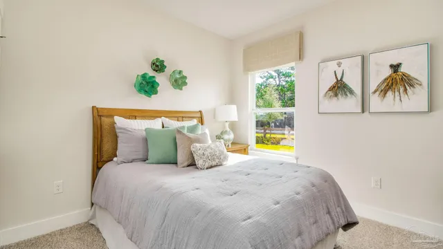 a bedroom with a bed painting on wall and a window