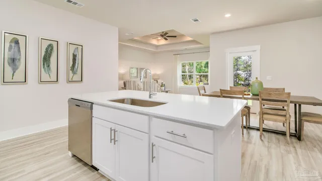 a kitchen with a sink cabinets and wooden floor