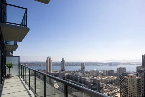 a bedroom with a bed and a large window with balcony view