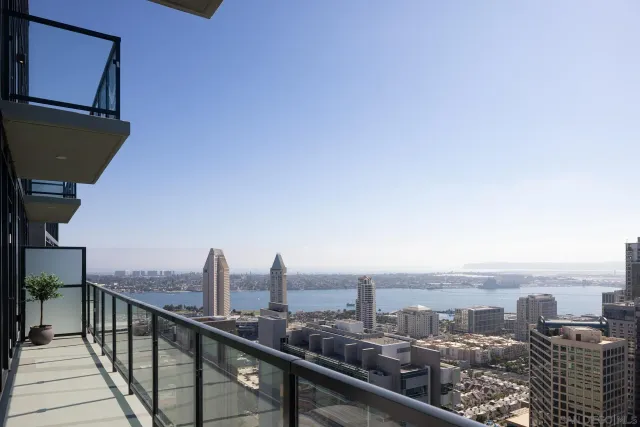 a bedroom with a bed and a large window with balcony view