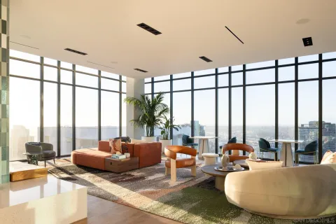 a living room with furniture and floor to ceiling windows