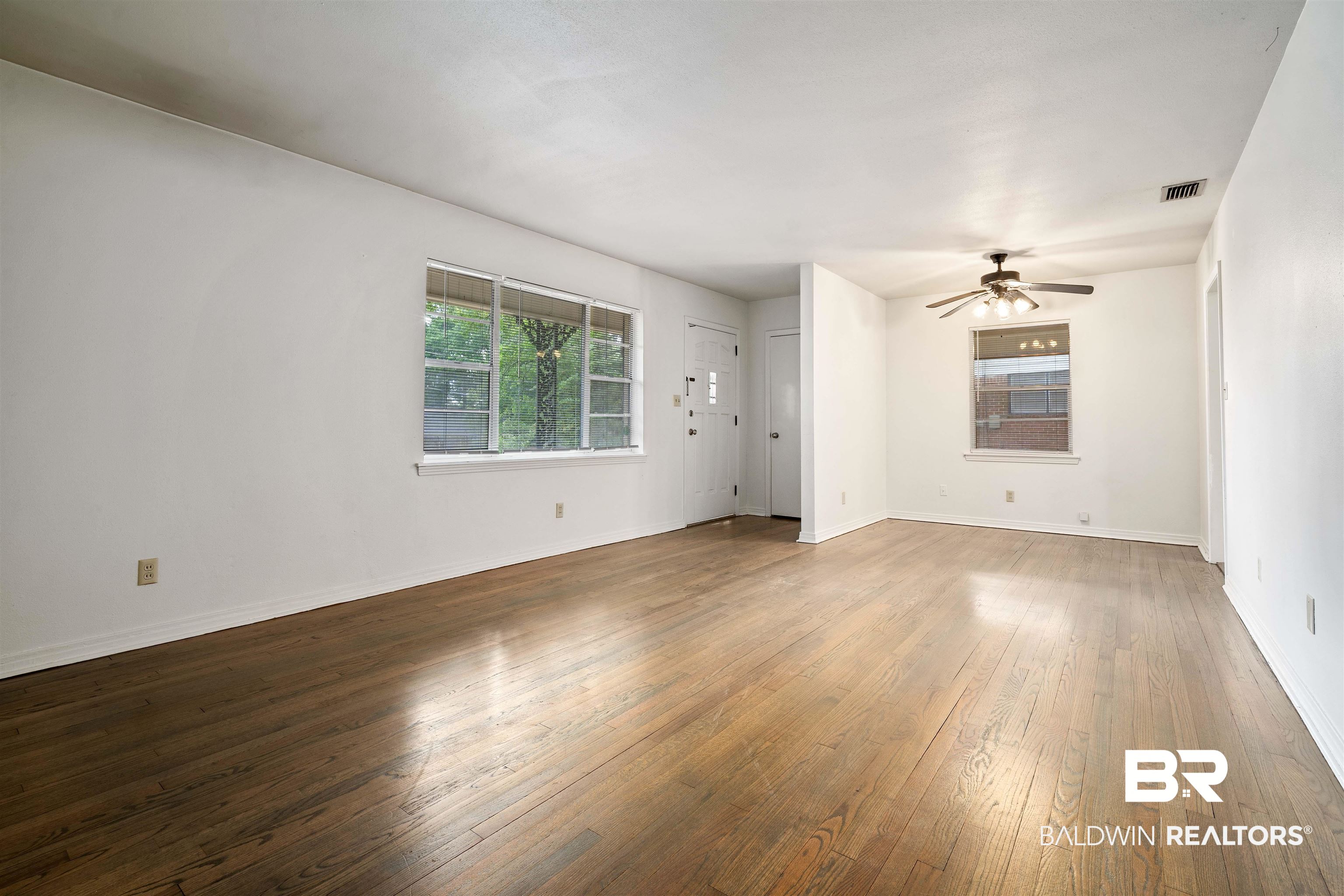 570 Markham Drive Mobile, AL 36609 - Photo 10 of 25 Spare room with baseboards, a ceiling fan, visible vents, and wood-type flooring