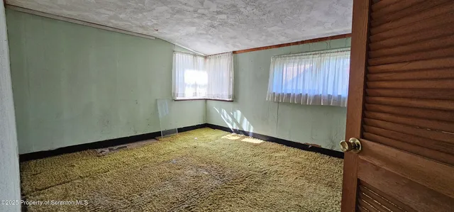 a view of brick house with a yard and plants