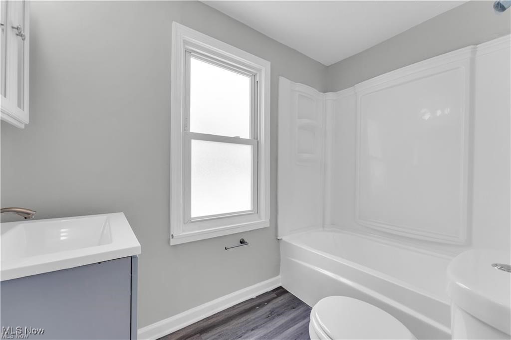 19600 Ridgewood Avenue Beachwood, OH 44122 - Photo 8 of 12 Full bathroom with toilet, vanity, hardwood / wood-style flooring, and a healthy amount of sunlight