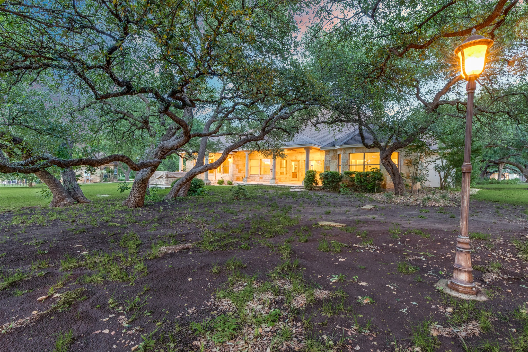 101 Copper Leaf Court Georgetown, TX 78633 - Photo 24 of 31 Stone-clad exterior featuring multiple windows, a covered patio, and a prominent outdoor lamp post