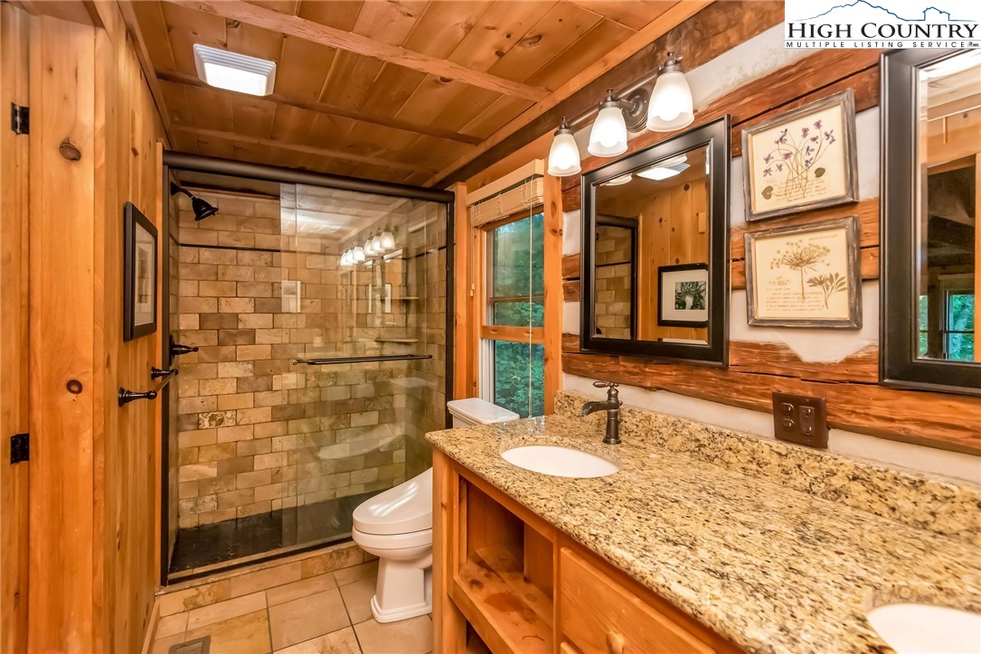 1810 Homestead Road Todd, NC 28684 - Photo 27 of 50 a bathroom with a granite countertop sink toilet and shower