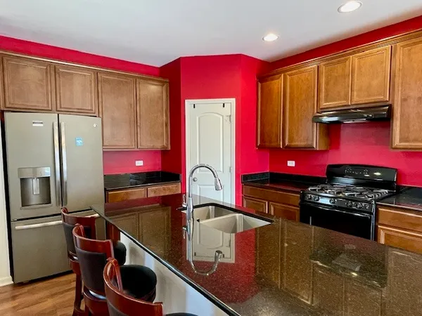 a kitchen with stainless steel appliances granite countertop a stove top oven a sink and dishwasher