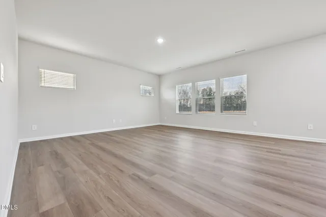 a view of large kitchen with wooden floor and windows