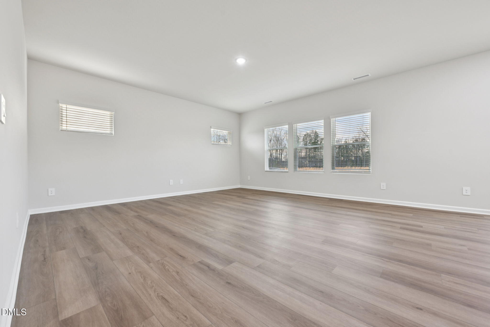 548 Bridger Drive Garner, NC 27529 - Photo 9 of 49 an empty room with wooden floor and windows