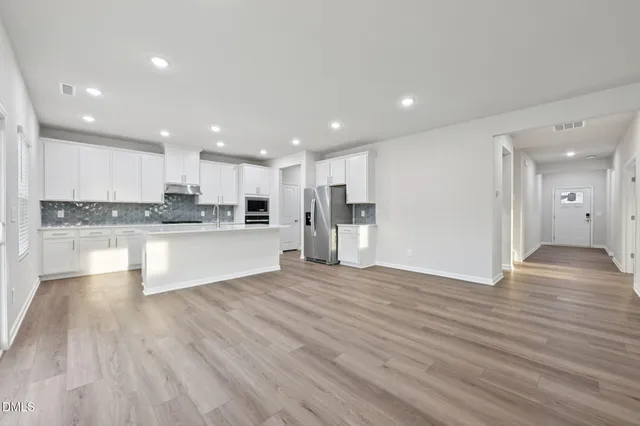 a kitchen with refrigerator cabinets and wooden floor