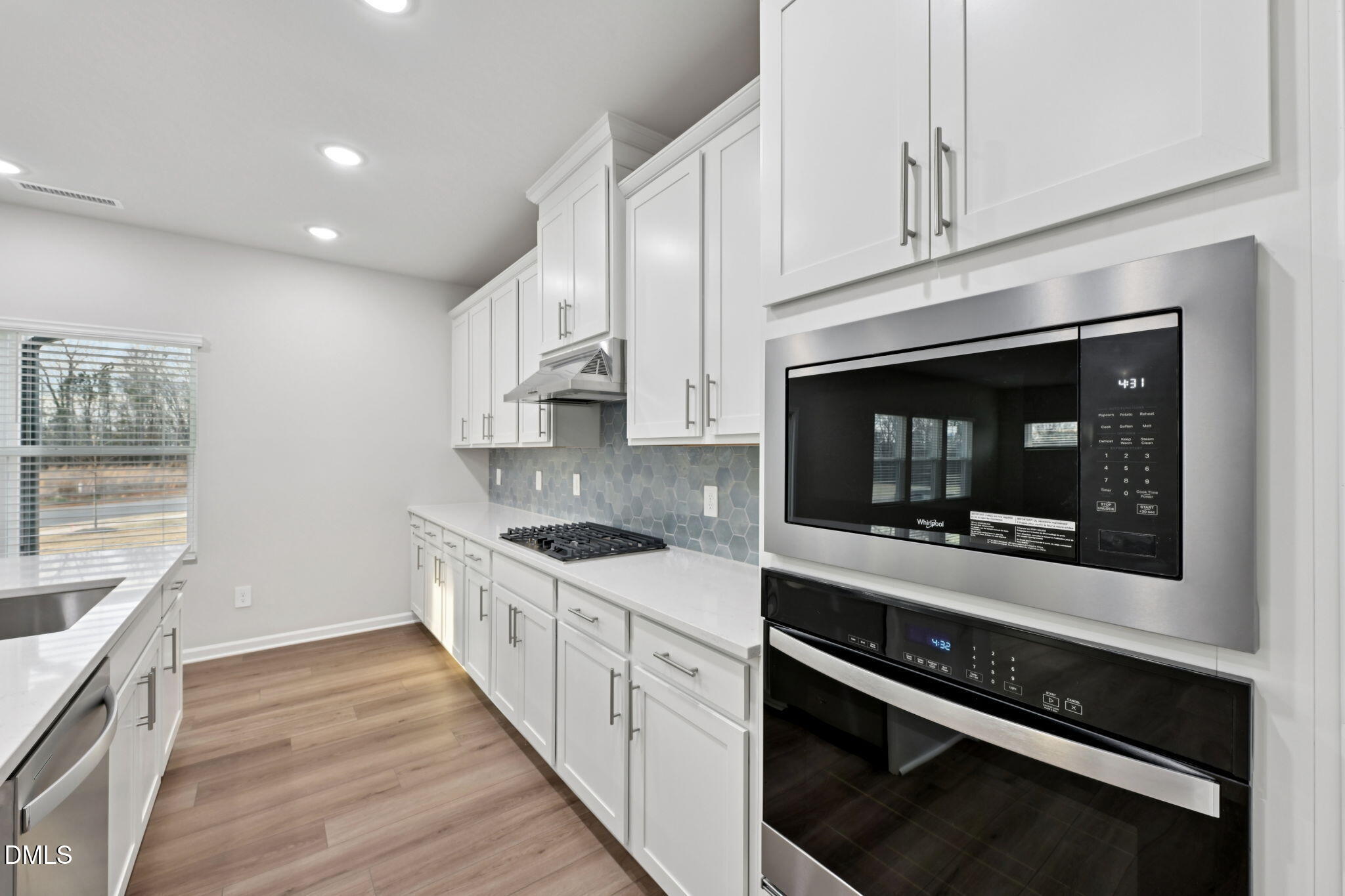 548 Bridger Drive Garner, NC 27529 - Photo 14 of 49 a kitchen with stainless steel appliances white cabinets and a stove top oven