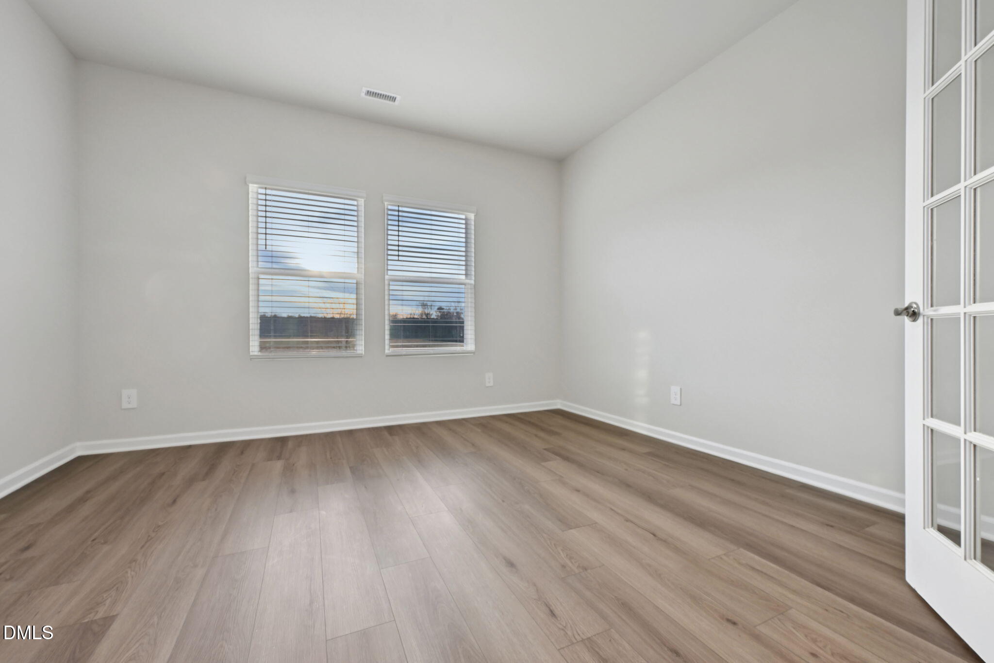 548 Bridger Drive Garner, NC 27529 - Photo 17 of 49 a view of an empty room with wooden floor and a window