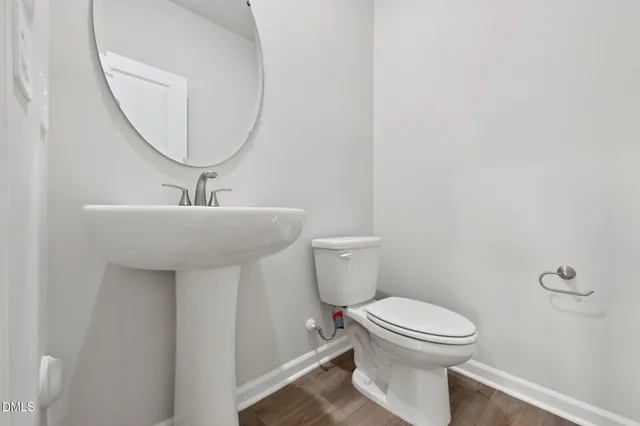 a bathroom with a shower sink vanity mirror and toilet