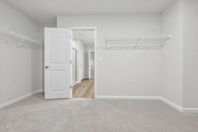 a view of walk in closet with empty racks
