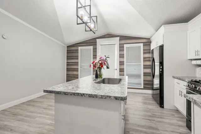 a kitchen with stainless steel appliances granite countertop a sink and a refrigerator