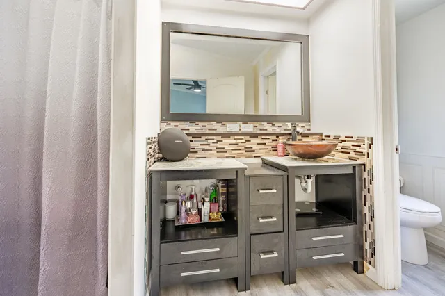 a bathroom with a toilet sink and mirror