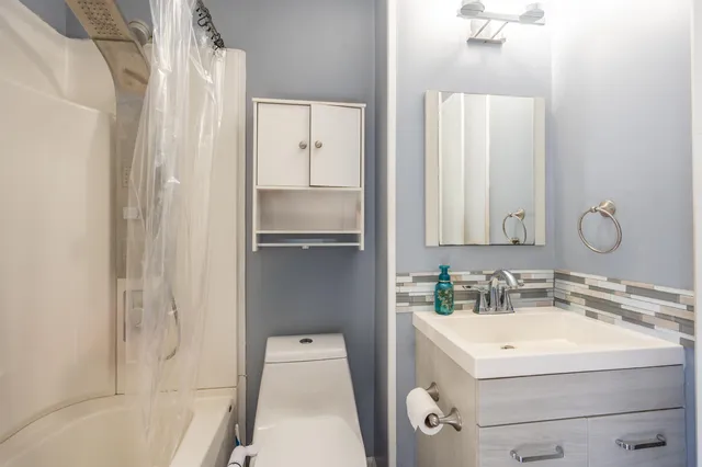 a bathroom with a sink a toilet and shower