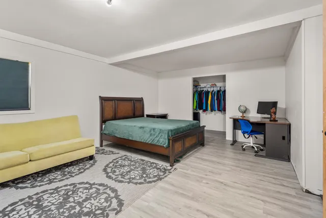 a bedroom with a bed a couch and a window