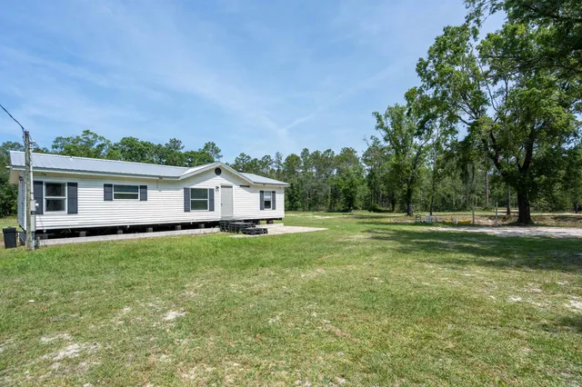 a view of a house with backyard and garden