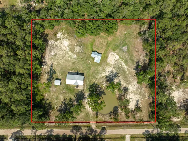 an aerial view of house with yard and swimming pool