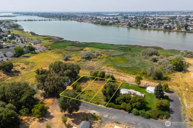 an aerial view of residential houses with outdoor space and lake view