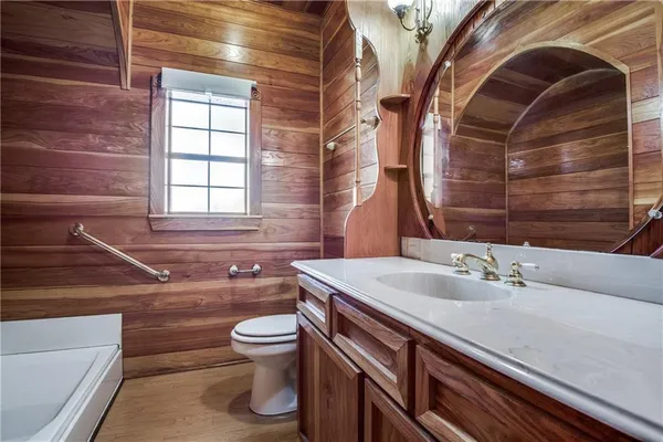 a bathroom with a sink a toilet and a mirror