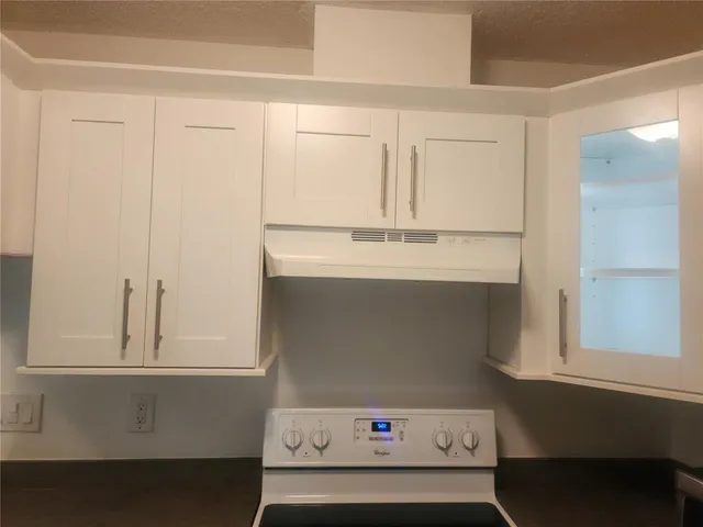 a kitchen with stainless steel appliances white cabinets and a stove