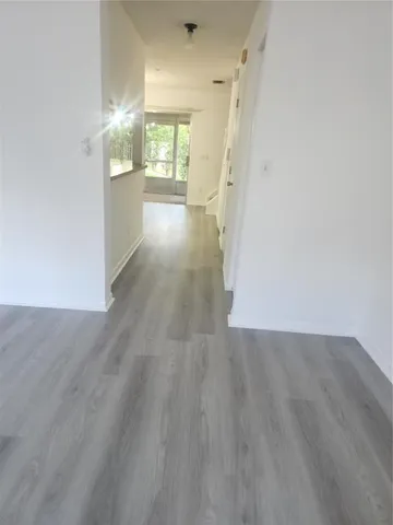 a view of a kitchen with a sink and wooden floor