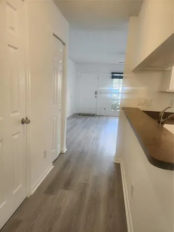 a kitchen with granite countertop a sink dishwasher stove and cabinets with wooden floor