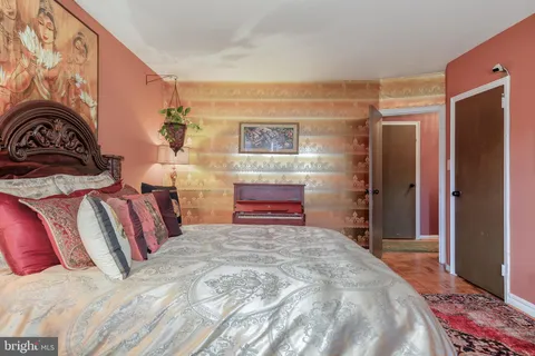 a bedroom with a bed and a painting on the wall