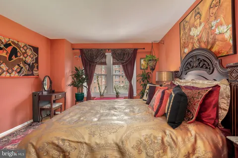 a bedroom with a bed and dresser with mirror