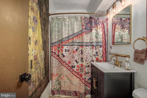 a bathroom with a sink and mirror with toilet