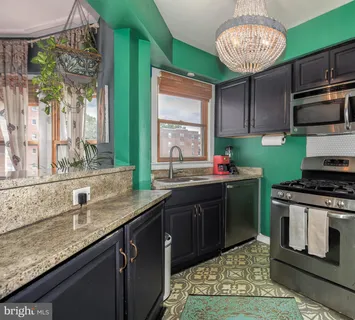 a kitchen with stainless steel appliances granite countertop a sink a stove and a wooden floors