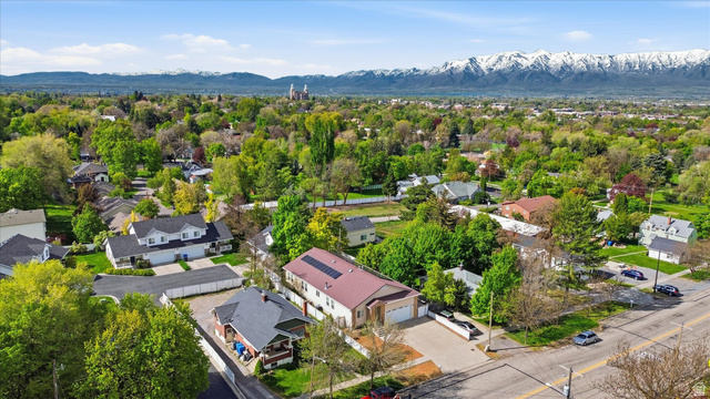560 East 700 North Logan, UT 84321 - Photo 30 of 32 Aerial perspective showcasing a residential area with mature trees and a distant mountain range