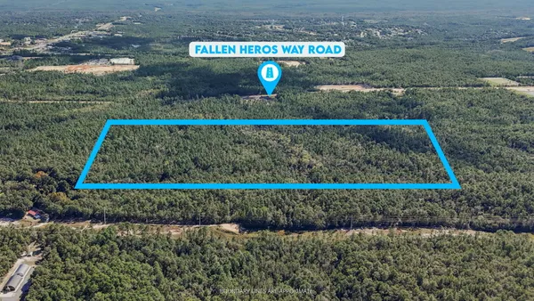 an aerial view of a city with lots of residential buildings ocean and mountain view in back