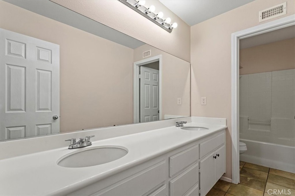 1128 East E Avenue Lancaster, CA 93535 - Photo 18 of 37 a bathroom with a granite countertop sink and a mirror