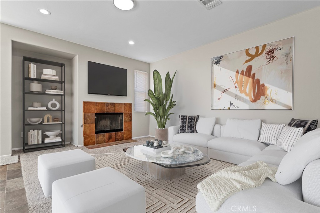 1128 East E Avenue Lancaster, CA 93535 - Photo 3 of 37 a living room with furniture a fireplace and a flat screen tv