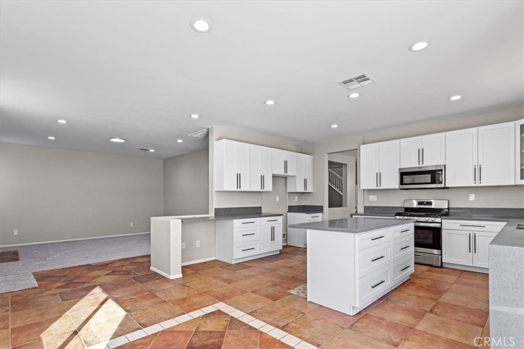 1128 East E Avenue Lancaster, CA 93535 - Photo 6 of 37 a kitchen with stainless steel appliances kitchen island granite countertop a sink and cabinets