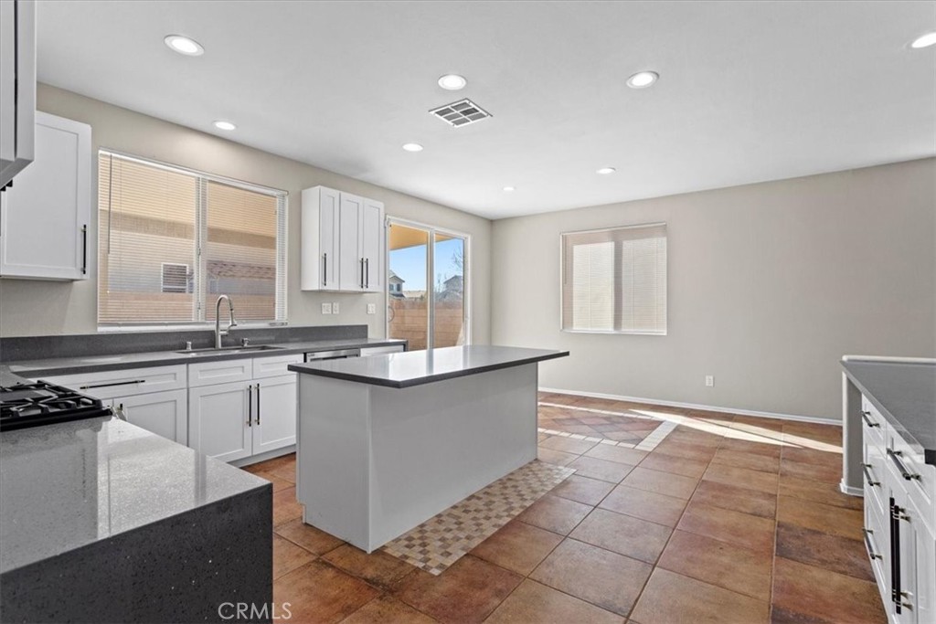 1128 East E Avenue Lancaster, CA 93535 - Photo 7 of 37 a large kitchen with stainless steel appliances granite countertop a sink and cabinets