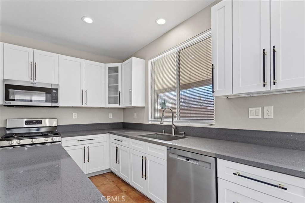 1128 East E Avenue Lancaster, CA 93535 - Photo 8 of 37 a kitchen with granite countertop white cabinets and white appliances