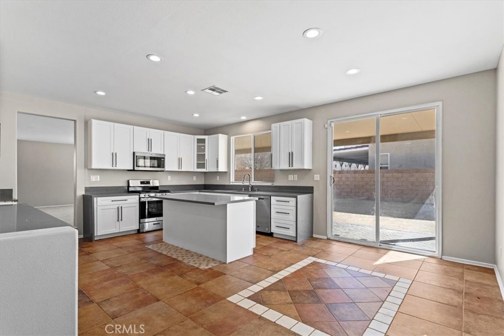 1128 East E Avenue Lancaster, CA 93535 - Photo 10 of 37 a kitchen with stainless steel appliances granite countertop a stove a sink a refrigerator and cabinets