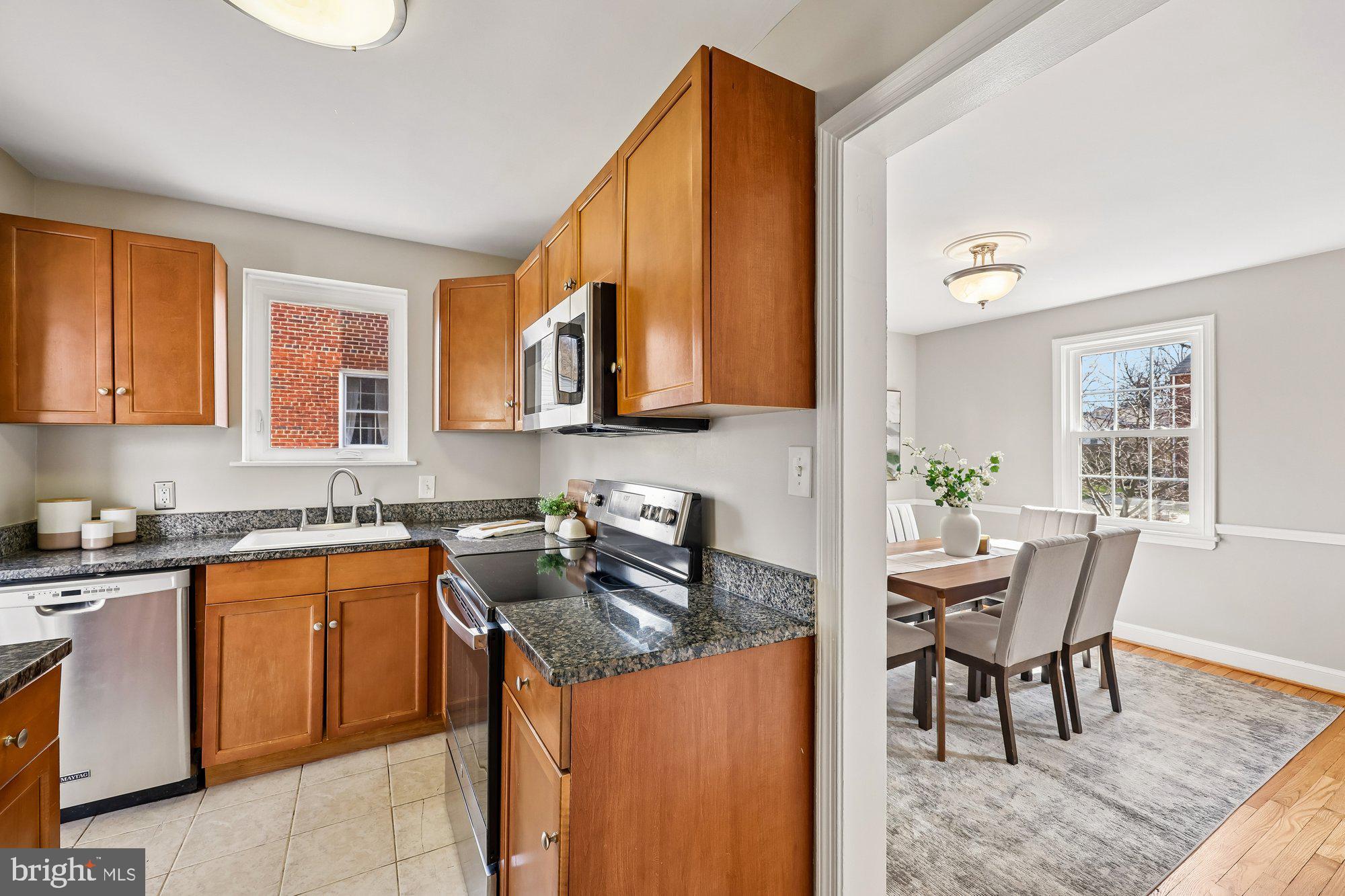 2613 Elnora Street Silver Spring, MD 20902 - Photo 15 of 54 a kitchen with a table chairs and a microwave