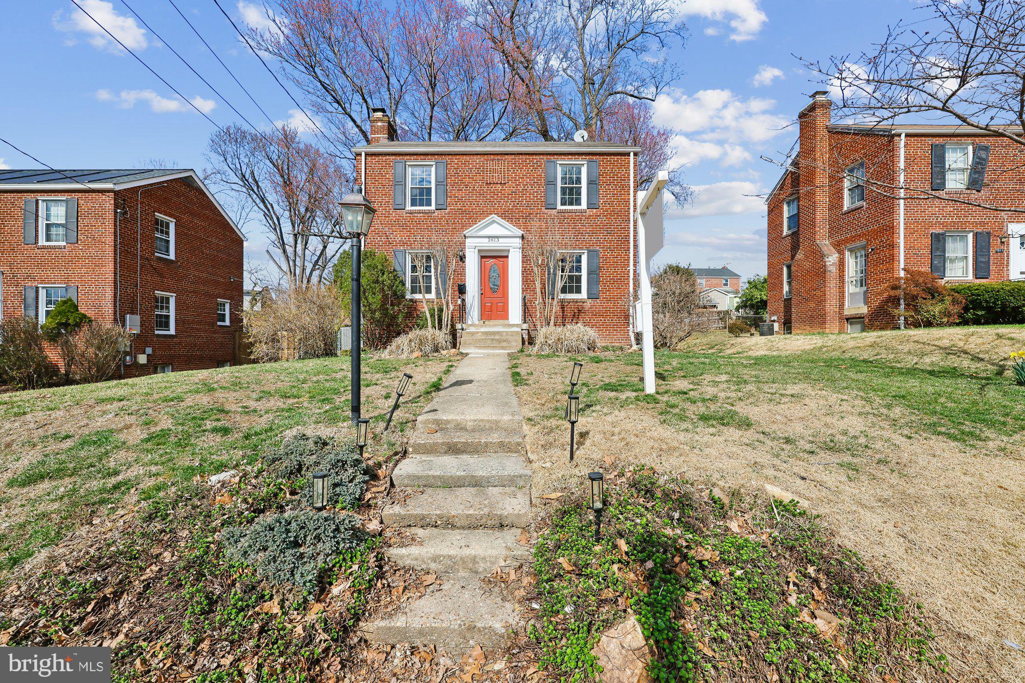 2613 Elnora Street Silver Spring, MD 20902 - Photo 2 of 54 a view of a brick house next to a yard with large trees