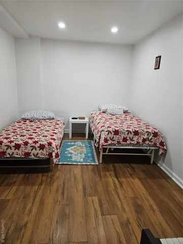 a bedroom with a bed and a wooden floor