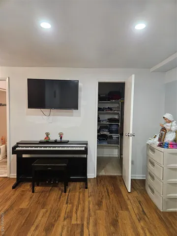 a living room with a flat screen tv and gym equipment