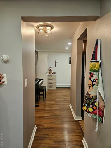 a view of a hallway with wooden floor and dining room