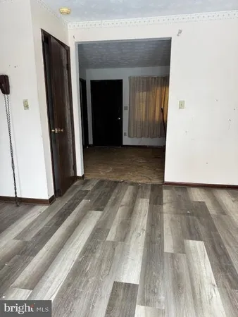 a view of a hallway with wooden floor and closet