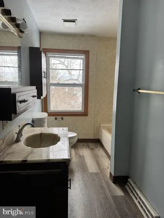 a bathroom with a granite countertop sink toilet and mirror