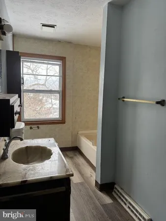 a bathroom with a sink a granite tub and shower